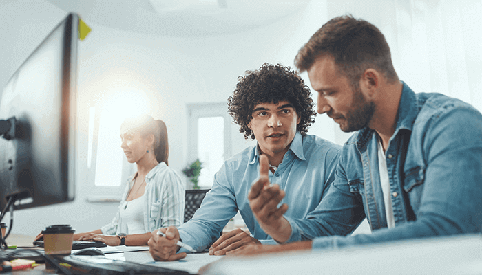 multiracial-colleagues-having-conversation-at-desk-males-and-female-working-on-computer-tinyfied-6-2